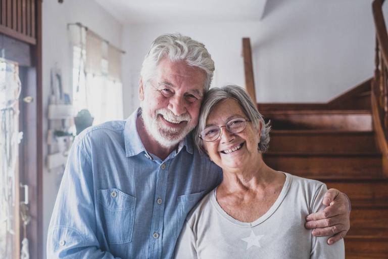 Portrait of happy couple old people seniors hug together, looking at the camera, loving to mature